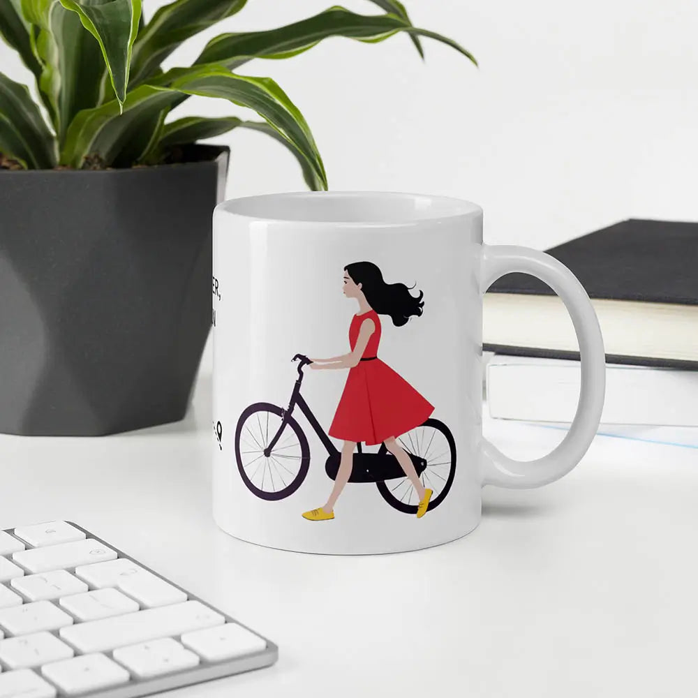 Weiße Tasse mit kreativem Radfahrmotiv und einer Frau und lebendigem Typografie-Design, das zu neuen Wegen inspiriert.
