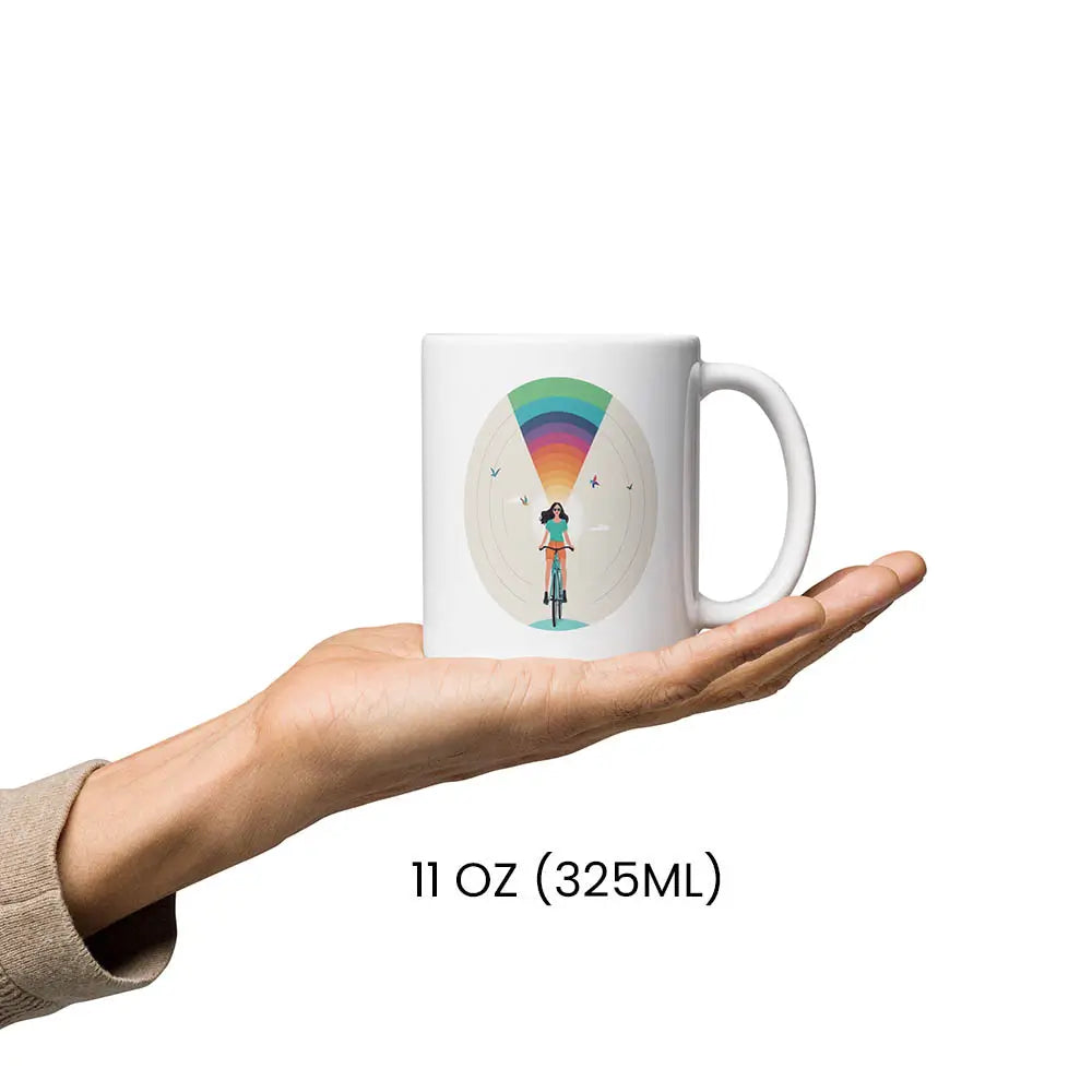 Weiße Tasse mit Regenbogen und Fahrradfahrerin