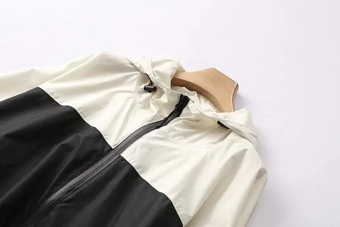 Regenponcho Damen mit Kapuze, Reißverschluss, Kordelzug, zweifarbig schwarz weiß am Bügel, Material wasserdicht