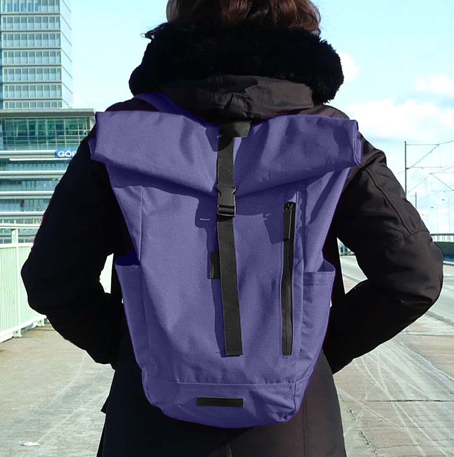 Frau mit blauen Rucksack in Stadtumgebung.