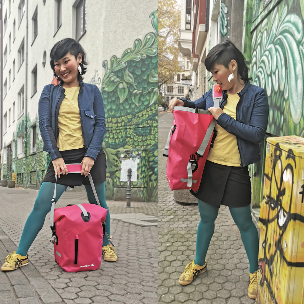 Asiatische Frau mit Fahrradtasche Damen auch als Umhängetasche nutzbar in der Stadt vor grünem Graffiti Hintergrund in Köln