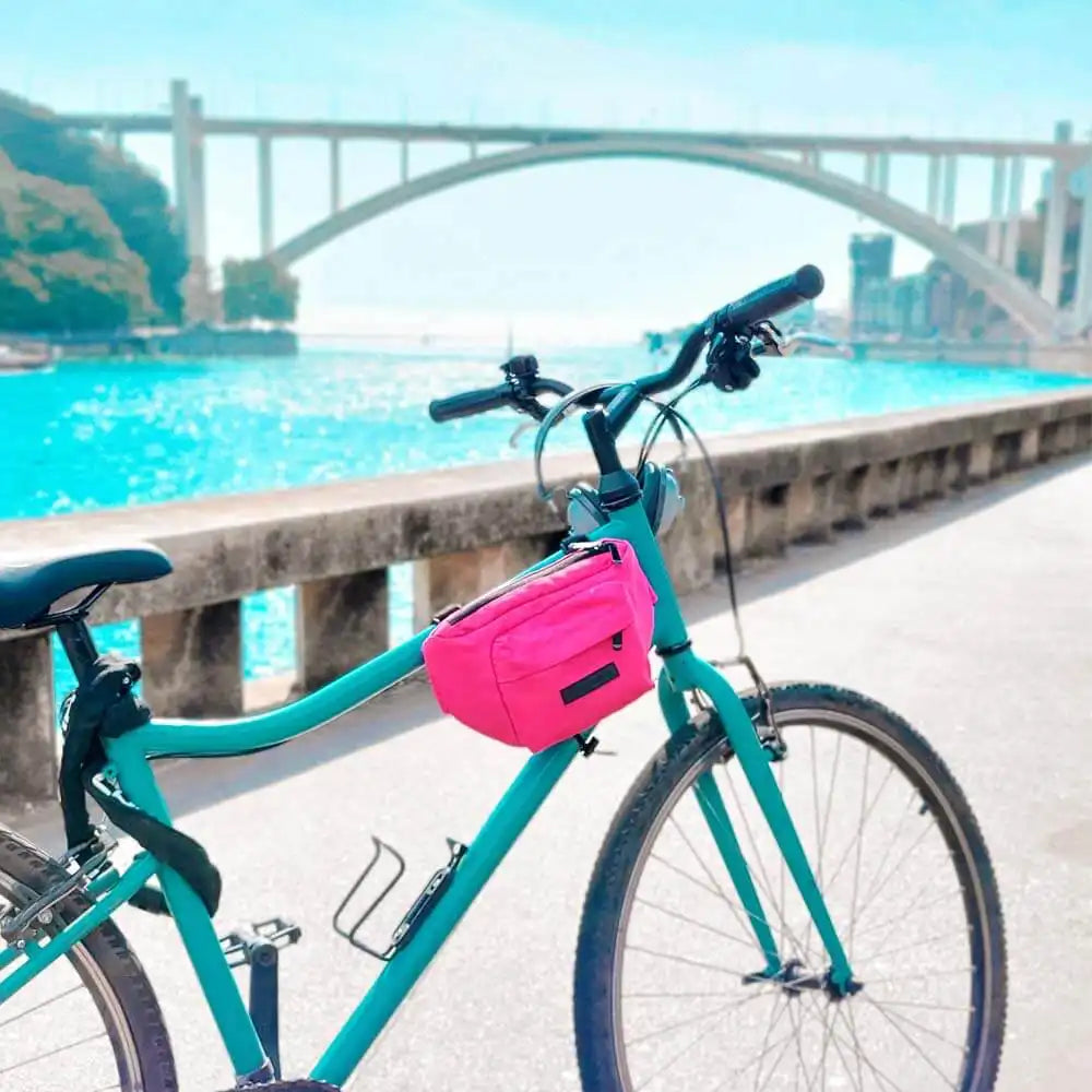 Fahrrad am Fluss mit pinker Rahmentasche. Outdoor mit Brücke.