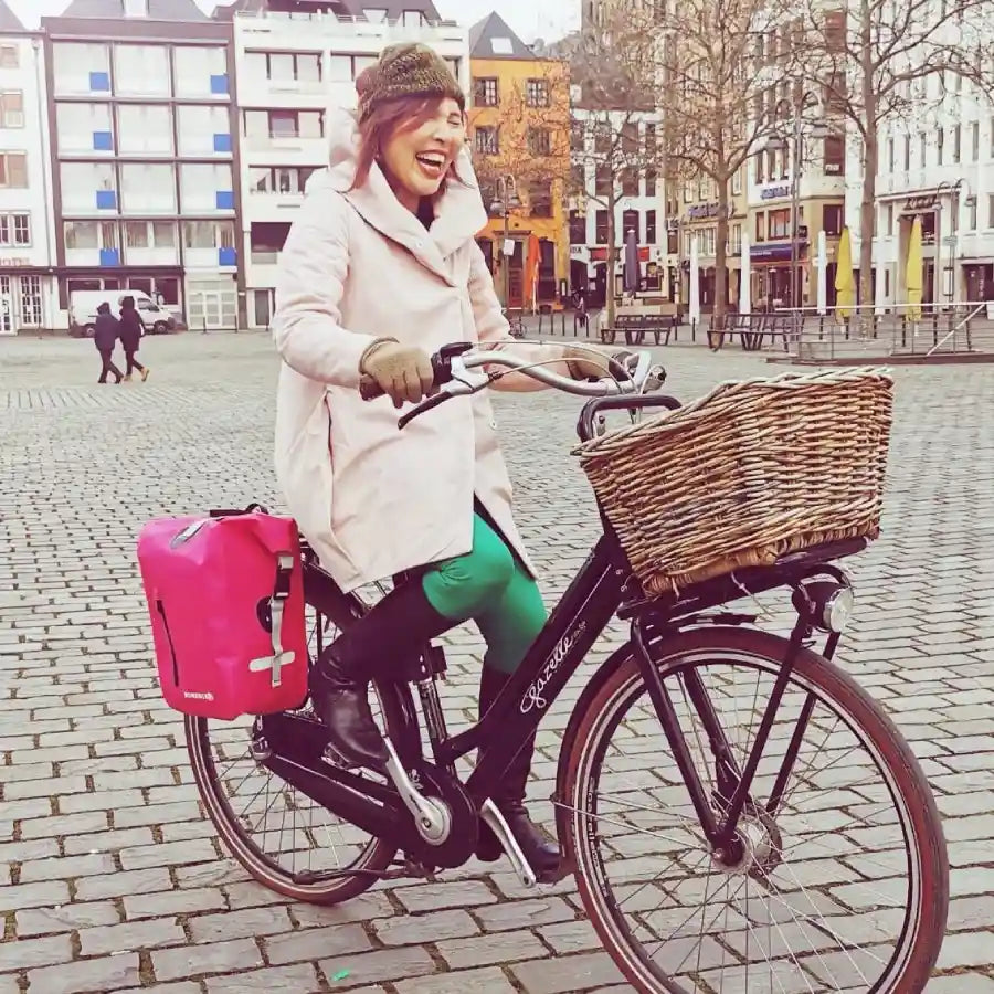 Dame auf dem Fahrrad in Köln mit pinker Fahrradtasche